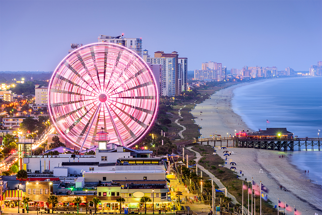 Myrtle Beach coastline at night with lite up boardwalk and Ferris Wheel