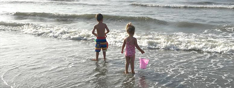 Little boy and girl standing in the ocean