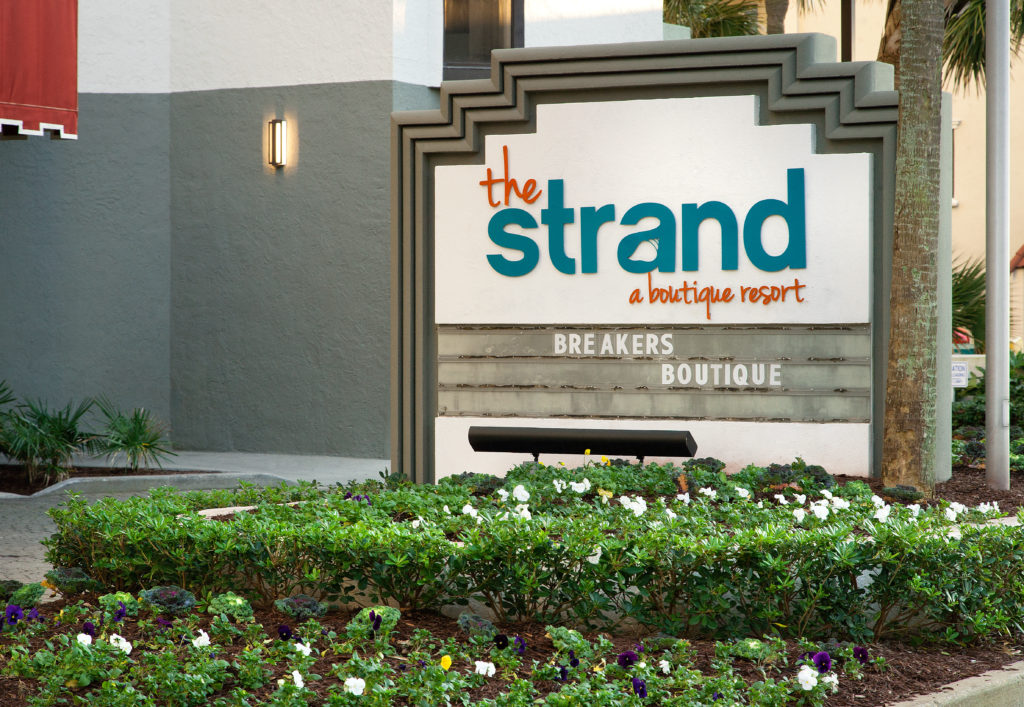 The strand sign outside in teal and orange writing