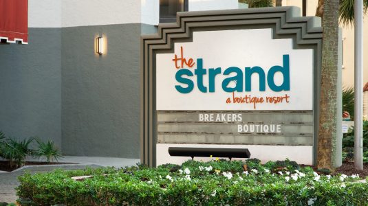 outdoor sign of the strand in blue and orange writing