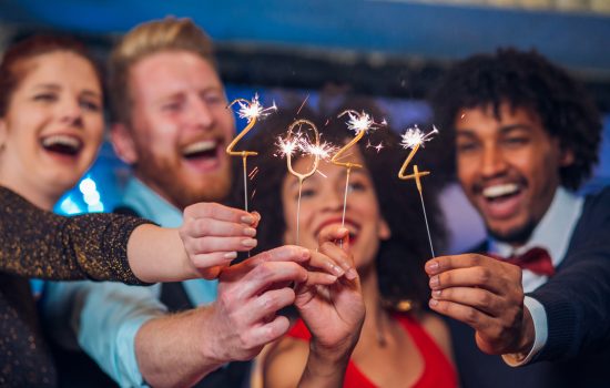 Young happy people looking at sparklers in their hands