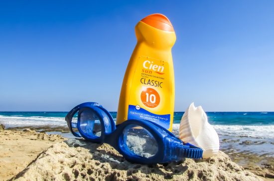 Sunscreen and goggles laying on the beach