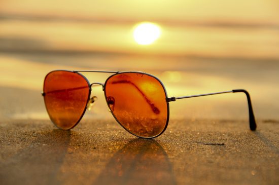 sunglasses on the beach during sunrise