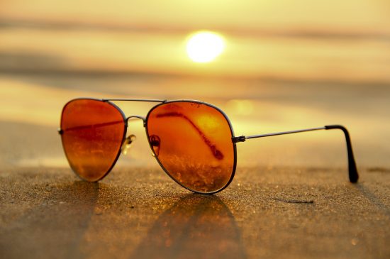 sunglasses on the beach during sunrise sunglasses on the beach during sunrise
